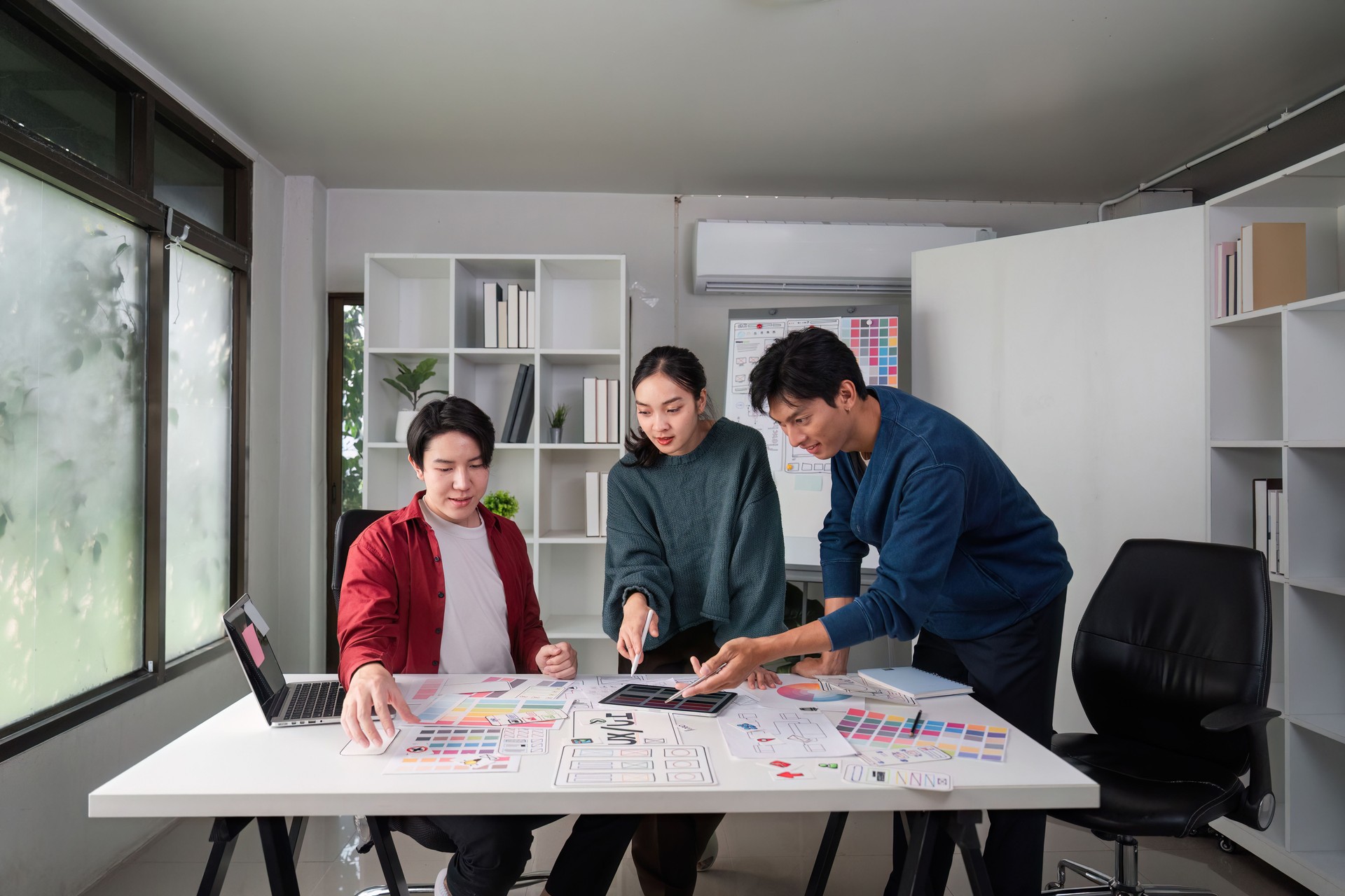 Teamwork and Design Process. Diverse designers collaborating on a UI/UX project in a creative workspace.