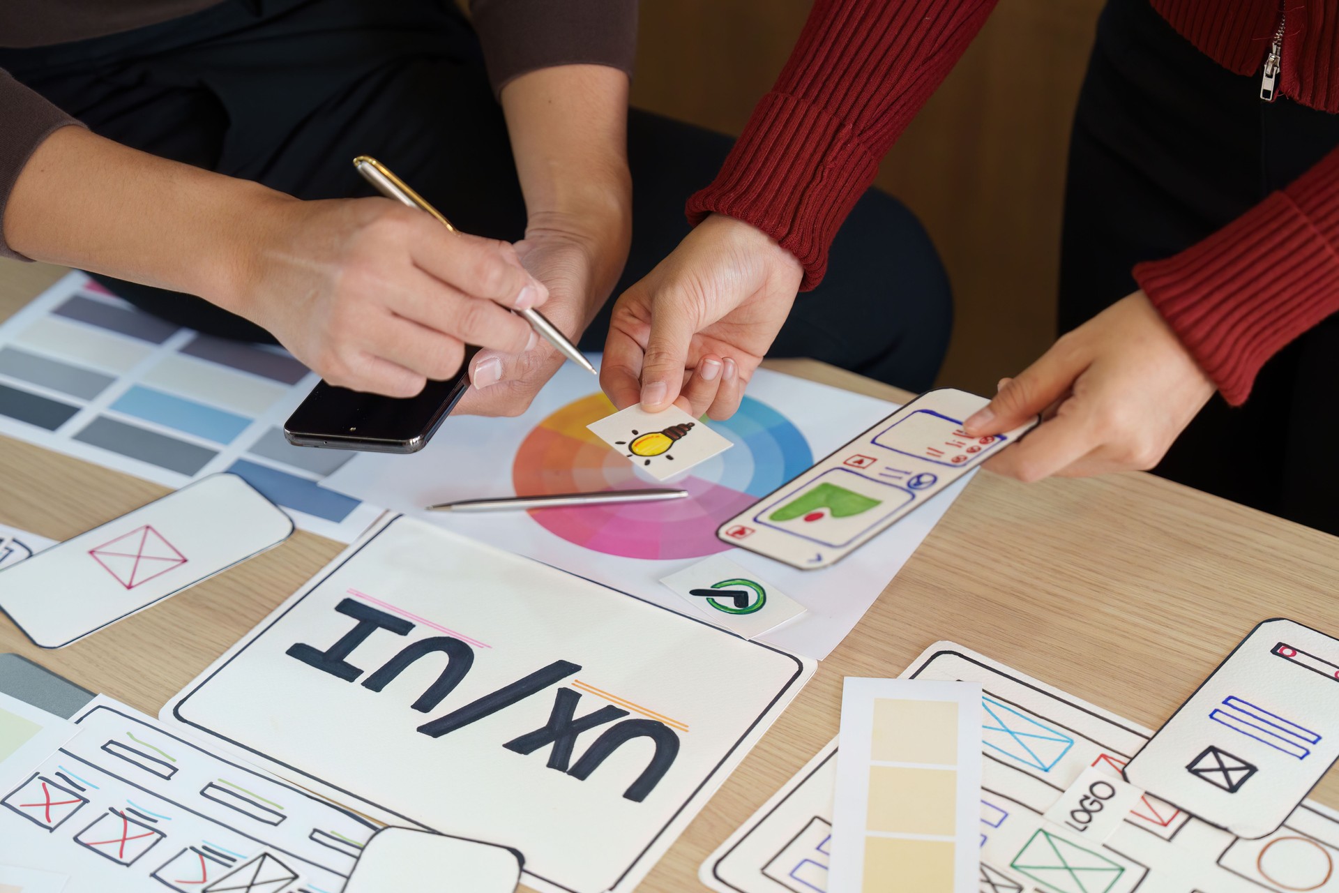 Design Exploration and Iteration. UX/UI designers analyzing design elements and color palettes for an innovative project.